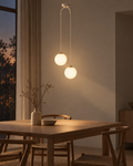 Orbe twin glass globe pendant in white above a pale dining table, hardware blending into the ceiling