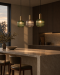 Velo bottle green glass pendant over a white kitchen island, the only colour in the room