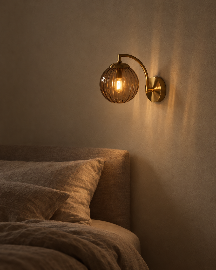 Riva coffee-tinted glass wall sconce against a clay-coloured wall above a walnut console