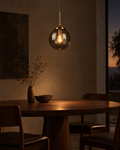 Monte small smoke glass pendant above a narrow console in a low-ceilinged room