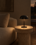 Nuvo matte black cordless table lamp on a terrace table after dark, body invisible against the night