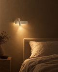 Sabbia white bedside wall light with ambient panel, reading spot and USB port beside a bed