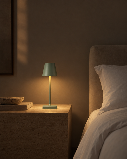 Cono small sage green USB touch lamp on a shelf of books
